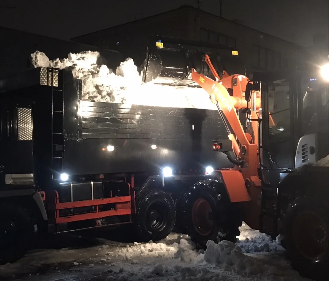 大型深箱ダンプへ雪を積み込む戸建て排雪の作業風景